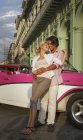 Молодая пара, опирающаяся на винтажный кабриолет, Гавана, Куба — стоковое фото
