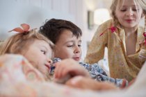 Дети в пижаме в постели — стоковое фото