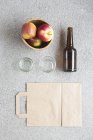 Яблоки, утилизируемые сумки и бутылки на столе — стоковое фото