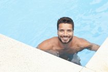 Mann steht im Pool und blickt in Kamera — Stockfoto