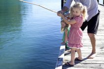 Homem e filhas pescando do cais, Nova Zelândia — Fotografia de Stock