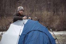 Mitte erwachsener Mann baut Zelt auf — Stockfoto