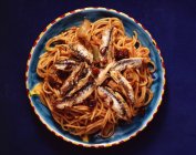 Sardines with spaghetti in bowl, top view — Stock Photo