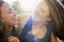 Close up of two teenage girls in sunlit park — Stock Photo