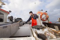 Fischer zieht Angelschnur auf Fischerboot — Stockfoto