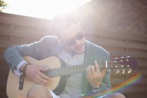 Mittlerer erwachsener Mann spielt auf Dachparty Gitarre — Stockfoto