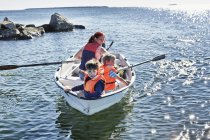 Мать с двумя маленькими сыновьями в лодке на озере, Гавле, Швеция — стоковое фото