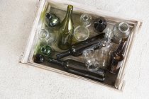 Wooden crate containing variety of empty bottles for recycling — Stock Photo