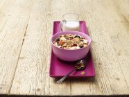 Tigela de café da manhã de muesli com frutas e leite em madeira — Fotografia de Stock