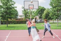 Friends playing basketball  together on court — Stock Photo
