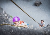 Boy wearing climbing helmet rock climbing — Stock Photo