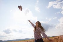 Взрослая женщина бросает шляпу в воздух — стоковое фото