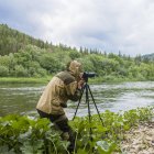 Männlicher Fotograf fotografiert ländlichen Fluss — Stockfoto