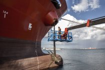 Worker on viewing platform inspecting oil tanker — Stock Photo