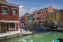 Casas multicolores y puente del canal, Burano, Venecia, Italia - foto de stock
