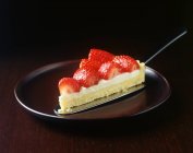 Slice of strawberry tart with cake server on plate — Stock Photo