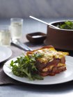 Veal and pork lasagne with arugula on plate — Stock Photo