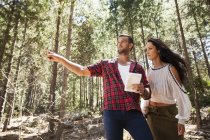Young couple in forest, man pointing — Stock Photo