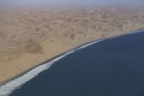 Namibia désert littoral couler autour de l'océan Atlantique vague — Photo de stock