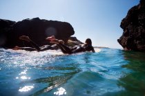 Casal deitado em pranchas de surf na água — Fotografia de Stock