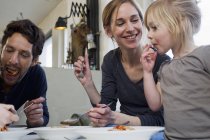Parents adultes moyens et deux filles mangeant des spaghettis — Photo de stock