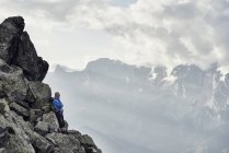 Зрелый человек, прислонившийся к камням, Вале, Швейцария — стоковое фото