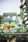 Rückansicht von Landwirt und Teenager-Enkel am Traktor — Stockfoto