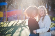 Портрет двох друзів-жінок, що обіймаються в парку — стокове фото
