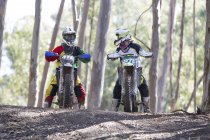 Dois jovens pilotos de motocross conversando na floresta — Fotografia de Stock