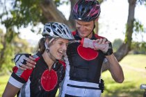 Male cyclist squirting water at woman's face — Stock Photo