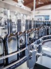 Flaschenreihen am Fließband in Fabrik — Stockfoto