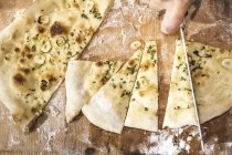 Abgeschnittenes Bild vom Koch, der Pizzateig in der Großküche schneidet — Stockfoto