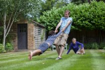 Dreigenerationenfamilie albert im Garten herum — Stockfoto