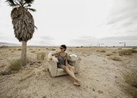 Junge Frau entspannt sich im Sessel in der Wüste — Stockfoto