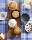 Cupcake alla vaniglia con selezione di condimenti e decorazioni — Foto stock