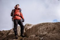 Молодой турист, выглядывающий со скал, Озерный округ, Камбрия, Великобритания — стоковое фото