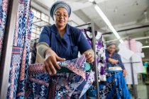 Рабочие гладильные платья на швейной фабрике — стоковое фото