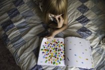 Junges Mädchen liegt auf dem Bett und liest Buch — Stockfoto