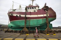 Чоловічий корабель художник ходити перед ловлячий рибу човен на drydock — стокове фото