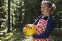 Woman in forest with mushrooms in saucepan — Stock Photo