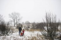 Pai e filhas na cena rural no inverno — Fotografia de Stock