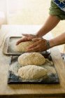 Imagem cortada de homem cozinhando loafs de pão — Fotografia de Stock