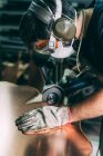 Trabajador metalúrgico moliendo el borde del cobre en taller de forja - foto de stock