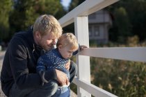 Father and toddler son looking through railing — Stock Photo