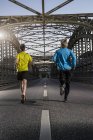 Friends jogging on bridge, Munich, Bavaria, Germany — Stock Photo