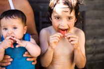 Felices hermanos comiendo sandía en el día de verano - foto de stock