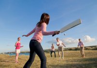 Family playing cricket together outdoors — Stock Photo