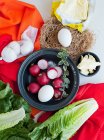 Редис, яйца и листья салата на ткани — стоковое фото