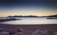 Scenic view of rocky seashore at sunset — Stock Photo
