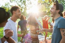 Group of adult friends chatting at party in park at sunset — Stock Photo